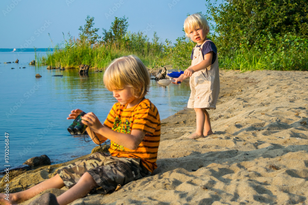 two brothers kids play near lake with binoculars, Uveldy, the Urals, Russia,