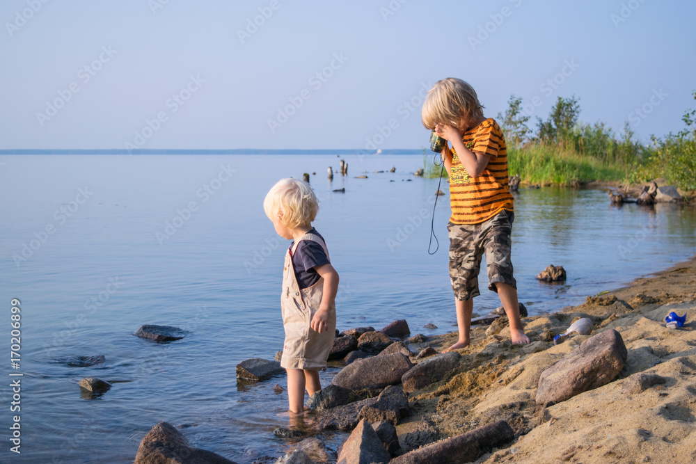 two brothers kids play near lake with binoculars, Uveldy, the Urals, Russia,