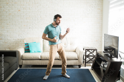 Attractive man dancing in the living room
