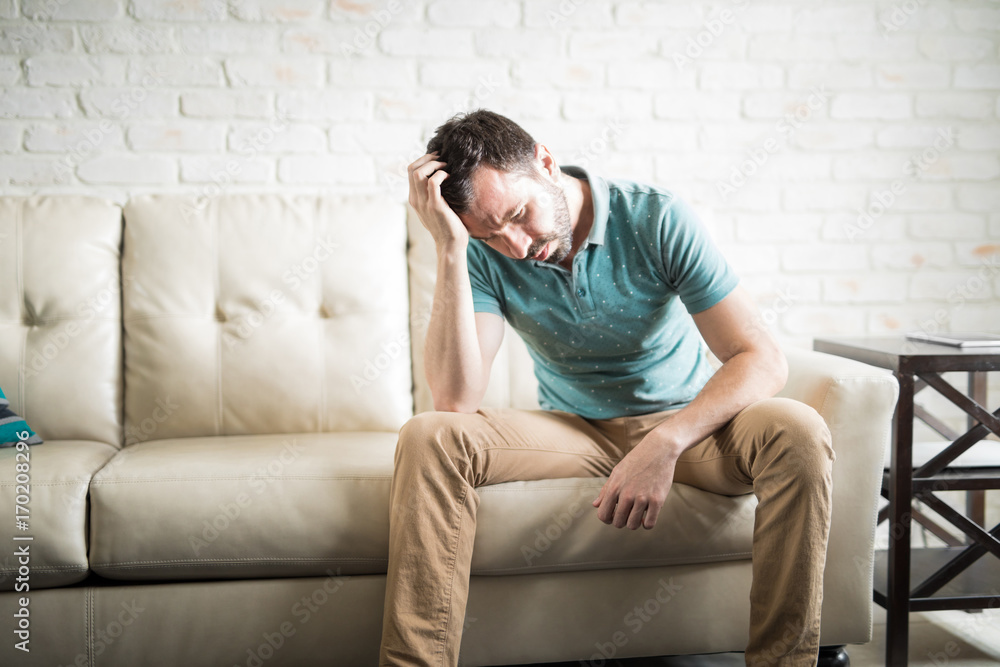 Sad man thinking in the living room Sad man thinking in the living room