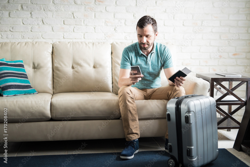 Latin man texting before traveling