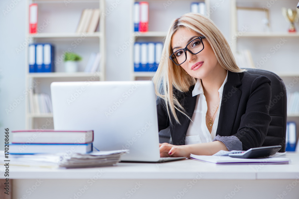 Businesswoman working on laptop at the desk in the office Businesswoman working on laptop at the desk in the office