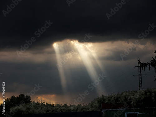 Sun shines through dark clouds