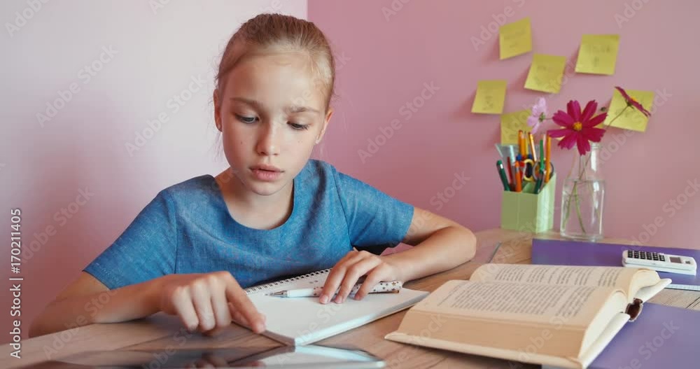 Portrait student girl 8 aged doing homework with help of tablet pc. Dolly shot Portrait student girl 8 aged doing homework with help of tablet pc. Dolly shot