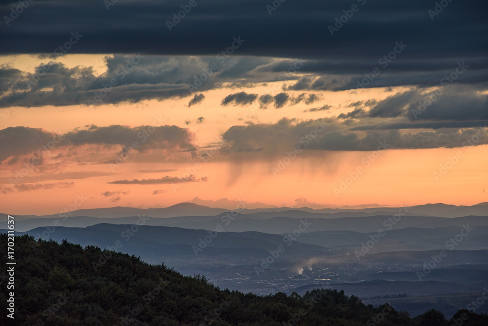 Powerful summer storm approaching the mountains in Sofia, Bulgaria under the beautiful golden light of the setting sun