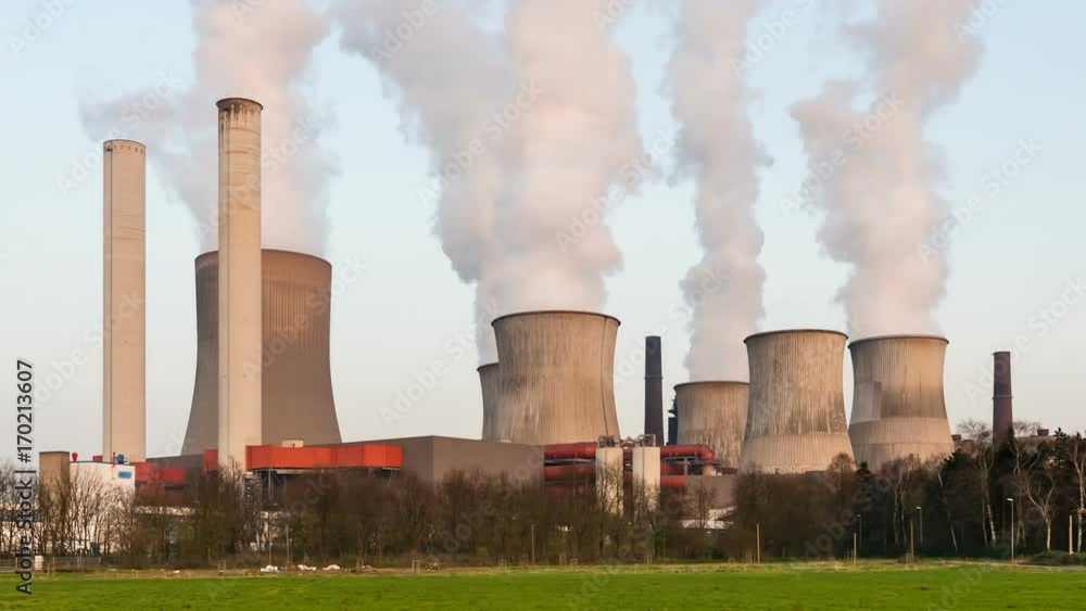 Day to night time lapse sequence of a large coal-fired power plant with a lot of steam and deep blue sky. Day to night time lapse sequence of a large coal-fired power plant with a lot of steam and deep blue sky.