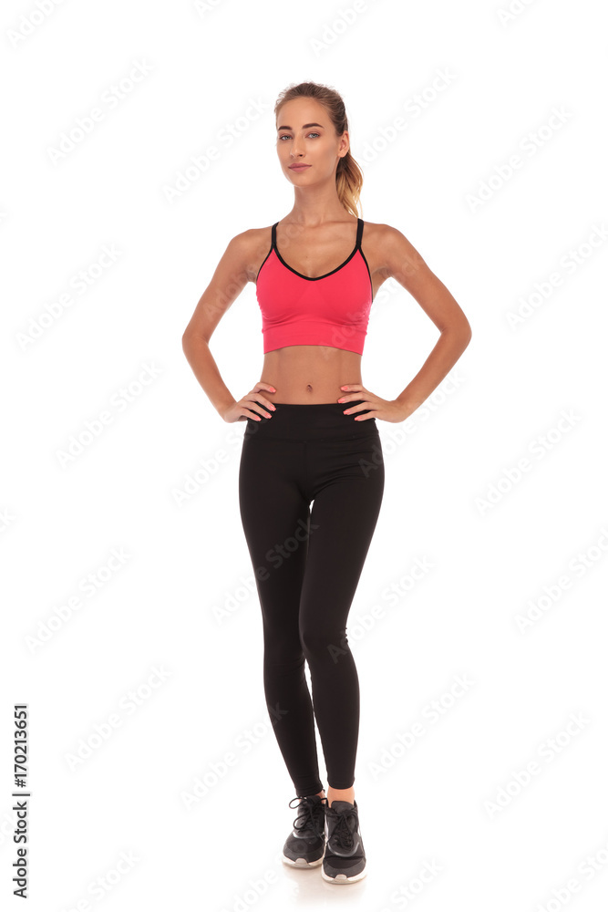 full body picture of a young fitness woman standing with hands on waist on white background full body picture of a young fitness woman standing with hands on waist on white background