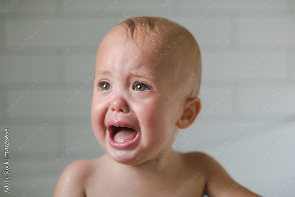 One-year-old baby cries close-up in the bathroom One-year-old baby cries close-up in the bathroom