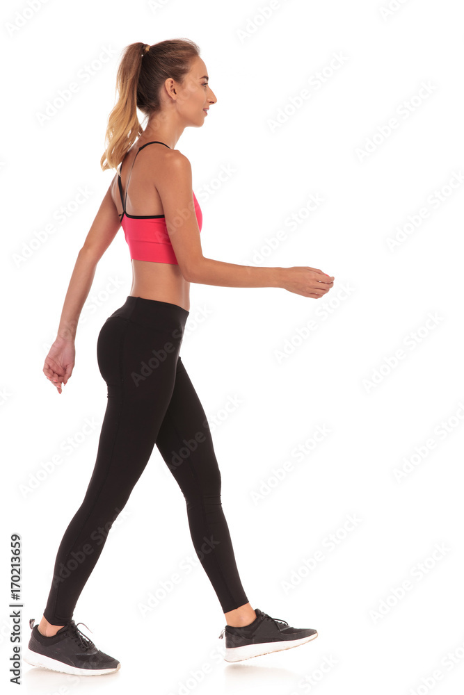 side view of a thin fitness young woman walking side view of a thin fitness young woman walking