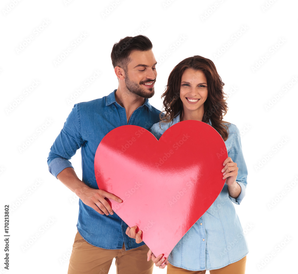 casual couple showing a big red heart casual couple showing a big red heart