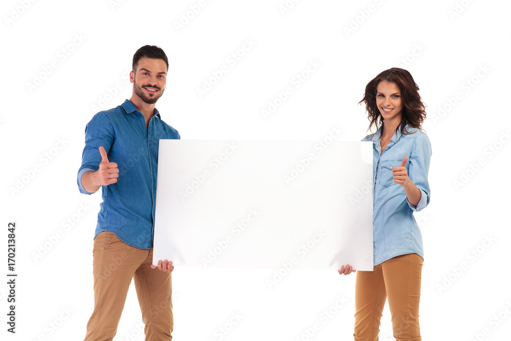 casual couple holding blank advertisement makes the ok sign casual couple holding blank advertisement makes the ok sign