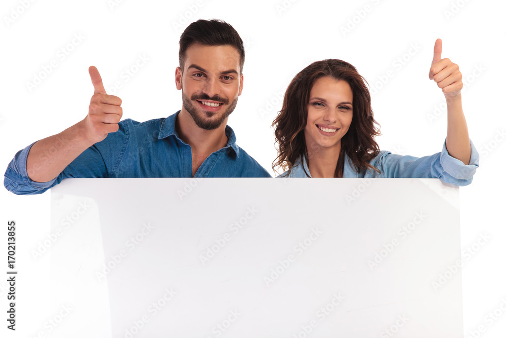 smiling couple over a blank board makes the ok sign