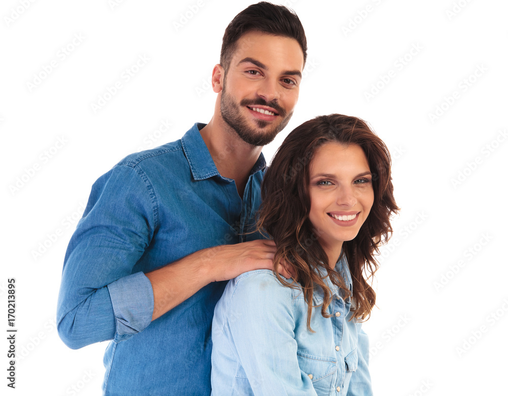 smiling casual man holding his woman by shoulders smiling casual man holding his woman by shoulders