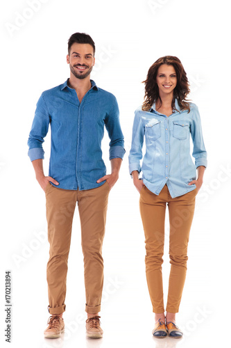 relaxed couple standing with hands in pockets photo