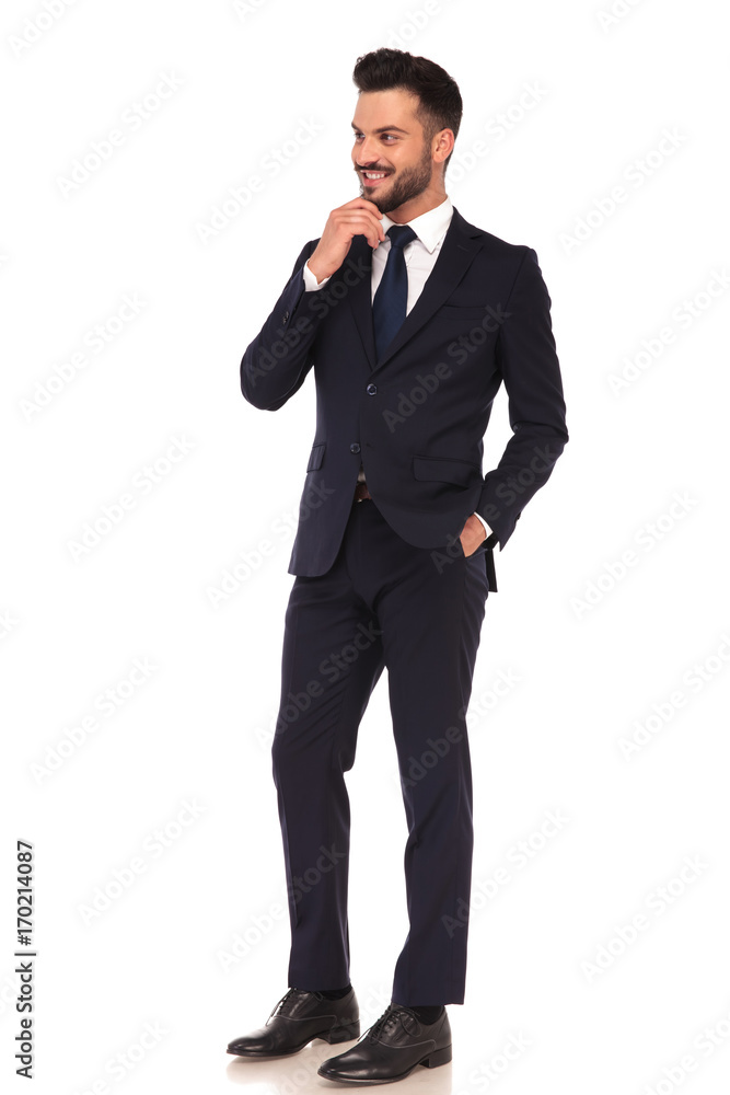smiling young business man holding his chin and thinking smiling young business man holding his chin and thinking