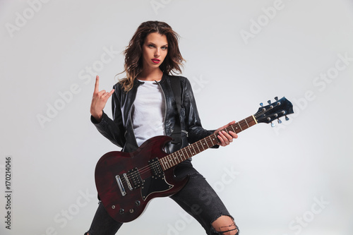 cool woman guitarist making a rock and roll hand sign Fototapet
