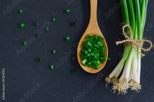 Foto Fresh spring onion on black granite table