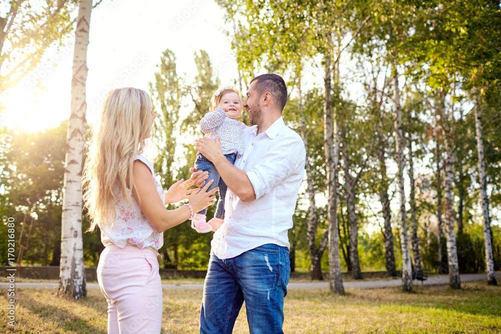 Happy family playing with the baby child in the park autumn summer. Happy family playing with the baby child in the park autumn summer.