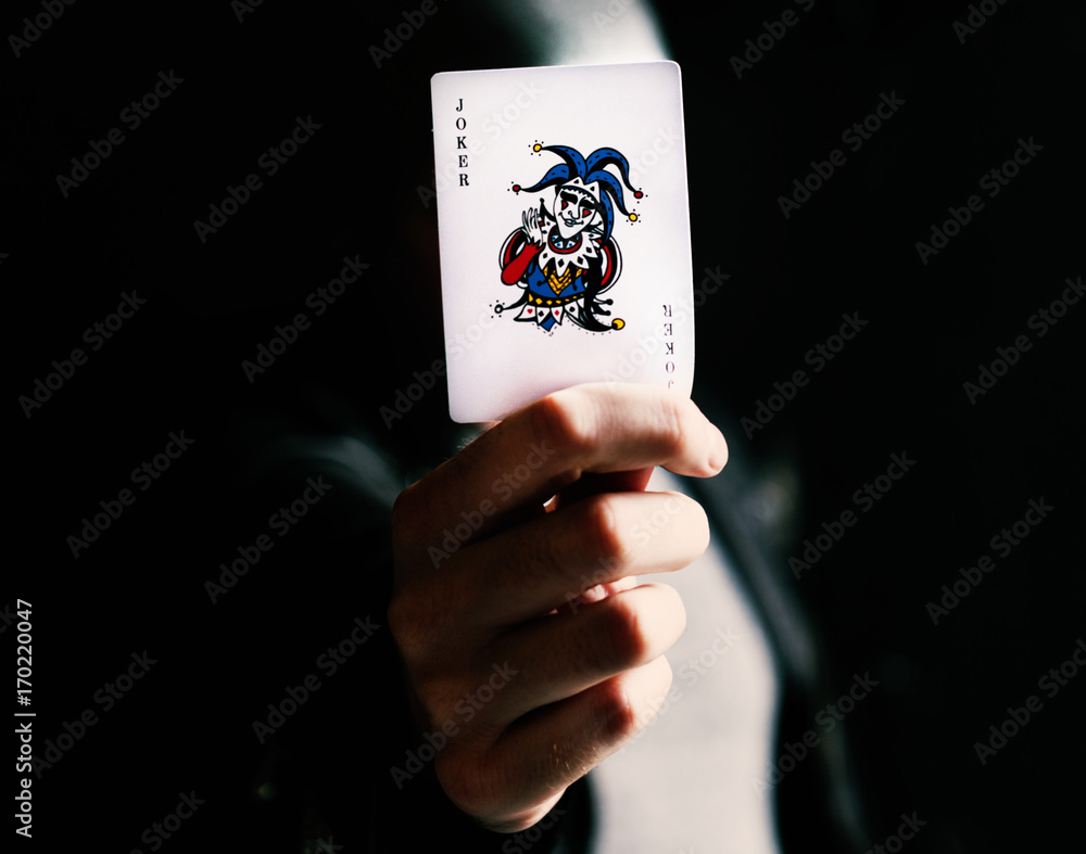 Hand holdign a joker card - obrazy, fototapety, plakaty 
