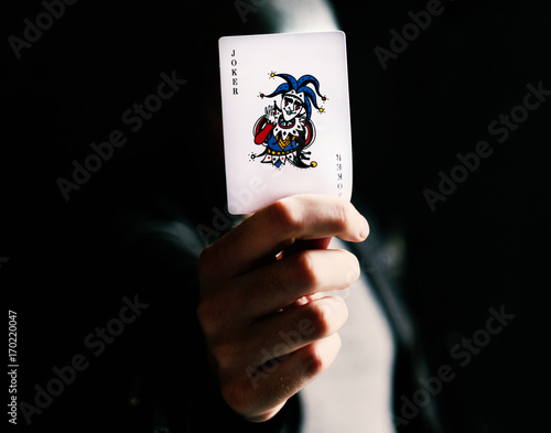 Hand holdign a joker card photo