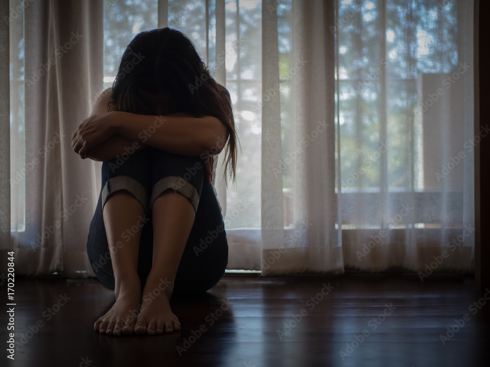 Closeup despaired woman hug her knee and cry while sitting alone on the floor. Closeup despaired woman hug her knee and cry while sitting alone on the floor.