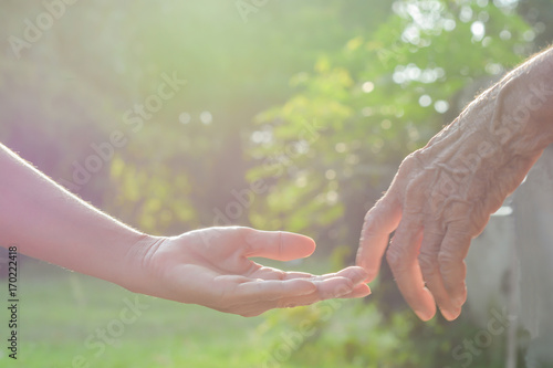 Hand,old and  hand with light of the morning © srisakorn