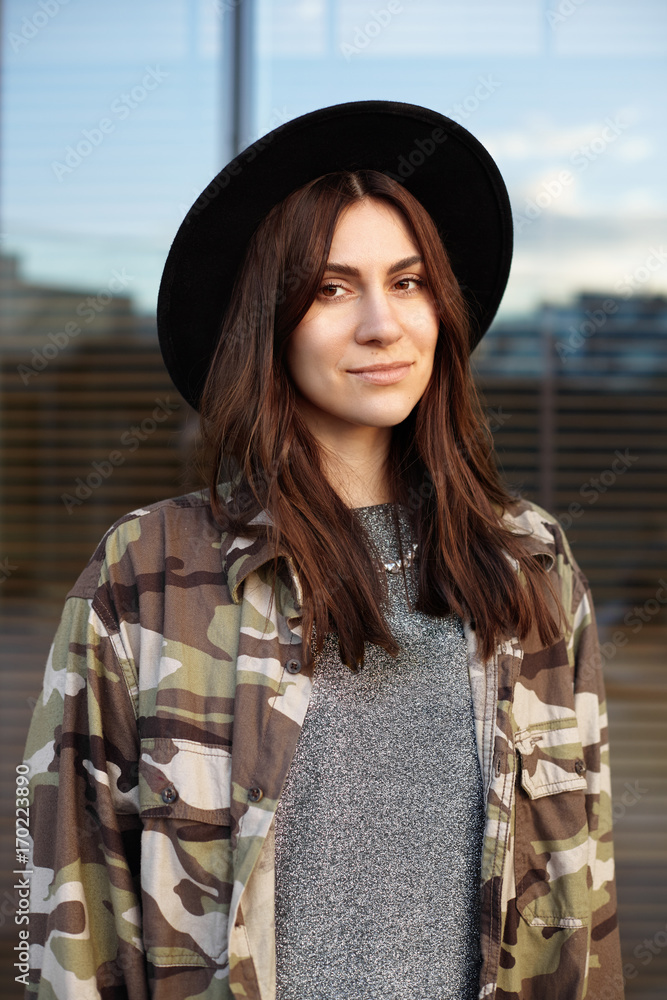 Beautiful brunette teenage girl wearing black round hat and trendy