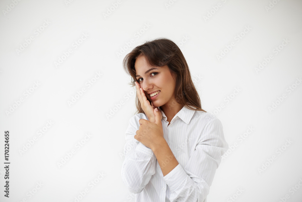 Waist up isolated portrait of attractive gorgeous Latin female office worker or student girl with long brown hair touching her face, having flirtatious playful look, smiling mysteriously at camera Waist up isolated portrait of attractive gorgeous Latin female office worker or student girl with long brown hair touching her face, having flirtatious playful look, smiling mysteriously at camera