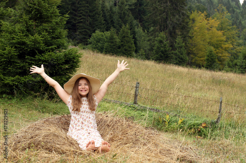beautiful little girl with hands up enjoys nature