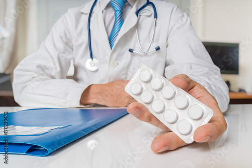 Doctor is giving painkiller pills to a patient.
