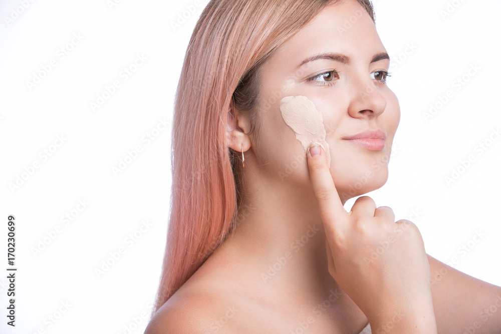 Young beautiful woman applying foundation base make up.. Isolated on white Young beautiful woman applying foundation base make up.. Isolated on white
