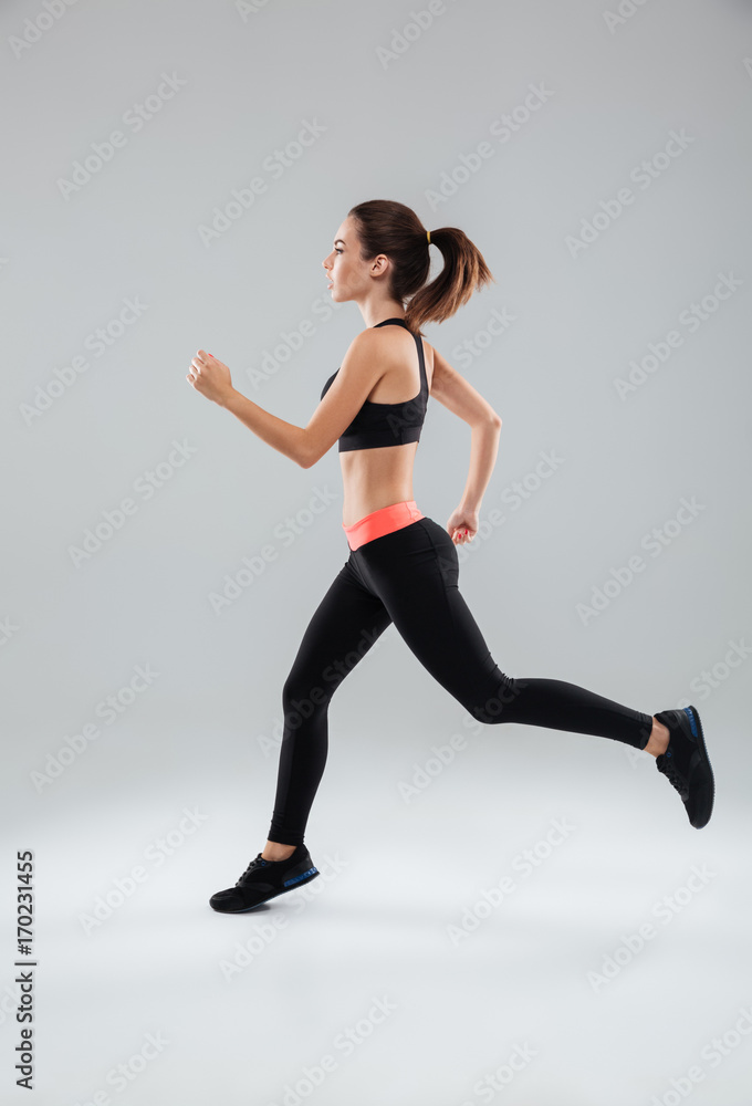 Full length picture of a sports woman running in studio