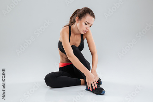 Young Upset fitness woman with pain in her leg