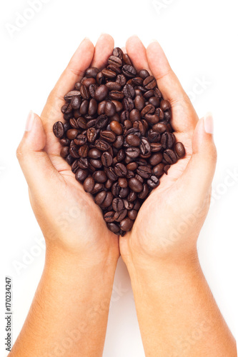 Hand holding coffee beans on white background