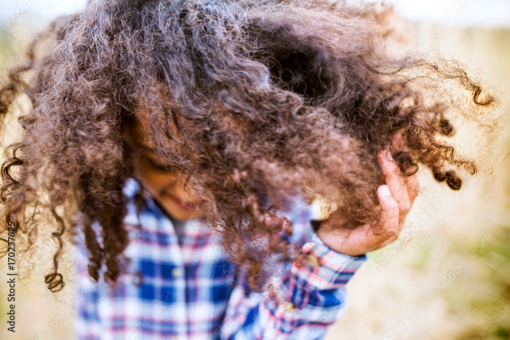 African american girl in checked shirt outdoors in field. African american girl in checked shirt outdoors in field.