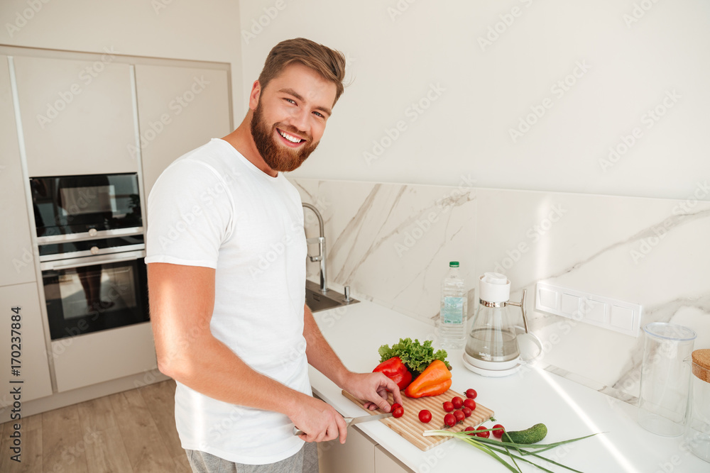 Side view of smiling bearded man with vegetable Side view of smiling bearded man with vegetable