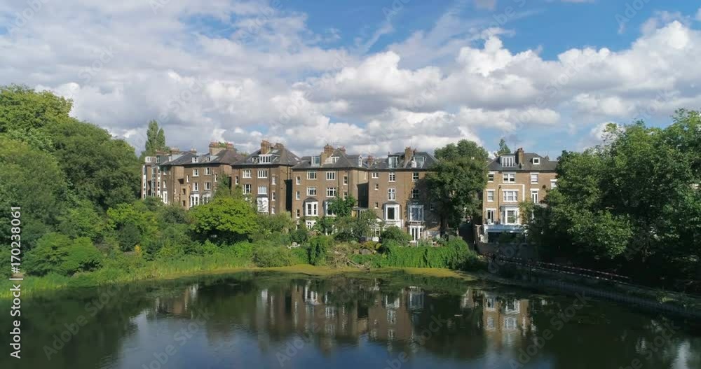 Aerial pull out view of Victorian houses reflecting on a pond in a park in North London Aerial pull out view of Victorian houses reflecting on a pond in a park in North London