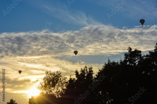 Three air balloons flying in sunset sky, beautiful cloudscape © kavunchik