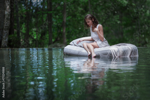 A hidden place. Sleeping woman in deep forest lies on airbed