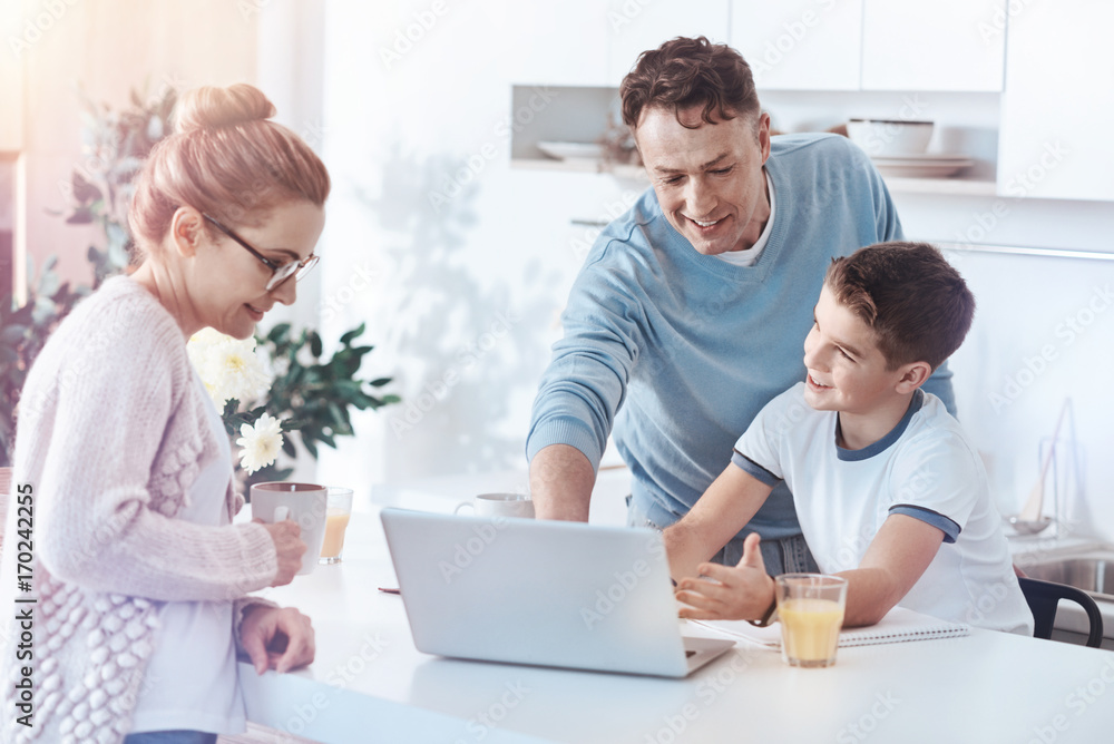 Mindful mom looking at father and son making presentation together Mindful mom looking at father and son making presentation together
