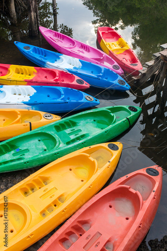 Group of colorful fiberglass kayaks on water in Thailand