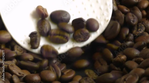 Man stirring fragrant coffee beans in frying pan