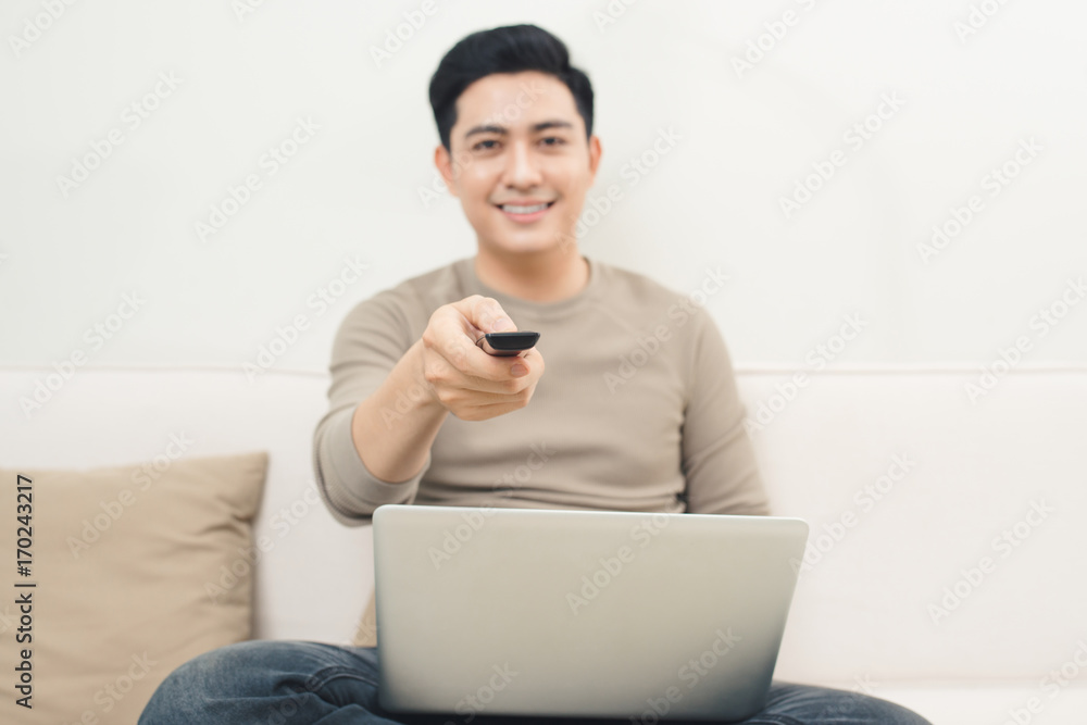 Young man using laptop and watching movies relaxed on couch at home Young man using laptop and watching movies relaxed on couch at home