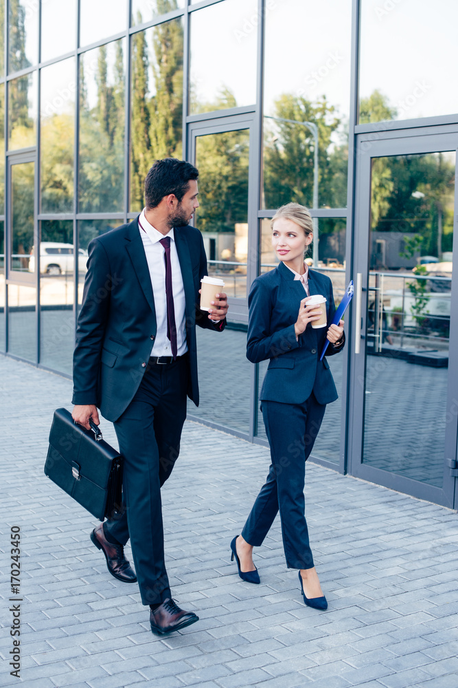 businesspeople walking with coffee businesspeople walking with coffee