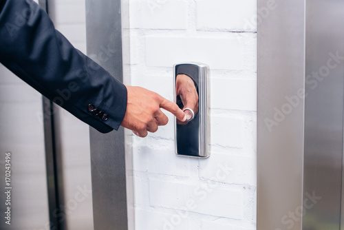 Man in suit pressing elevator button