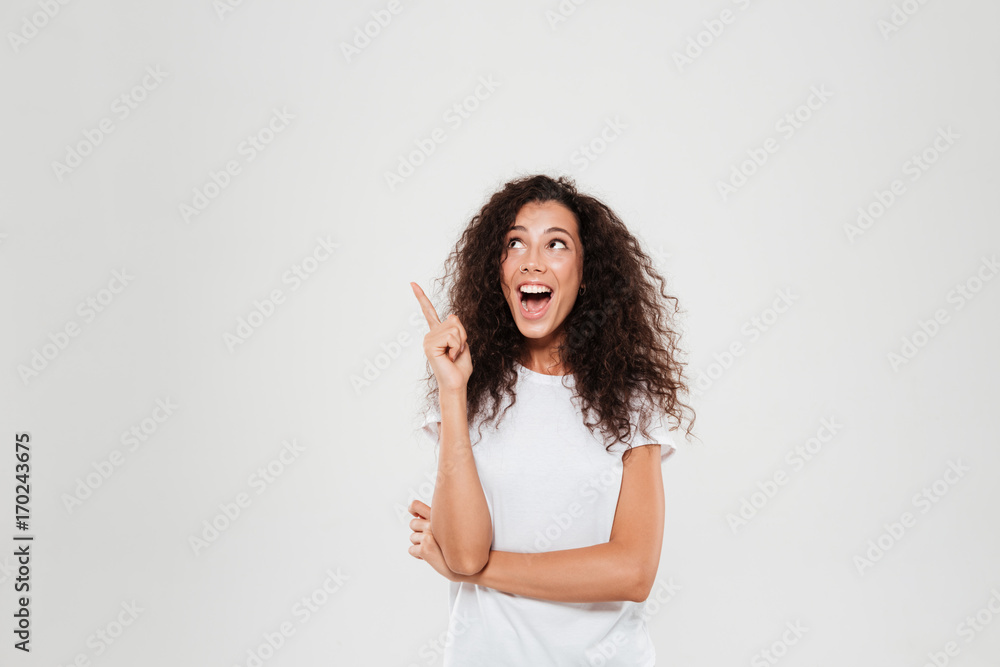 Happy curly woman having idea and showing forefinger Happy curly woman having idea and showing forefinger