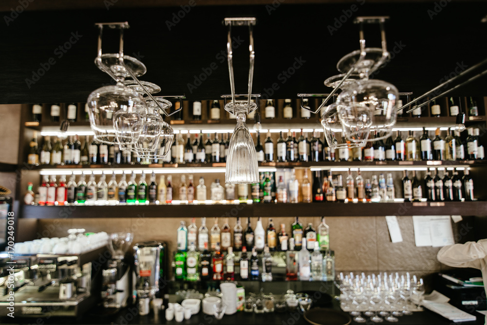 Empty glasses for wine above a bar rack