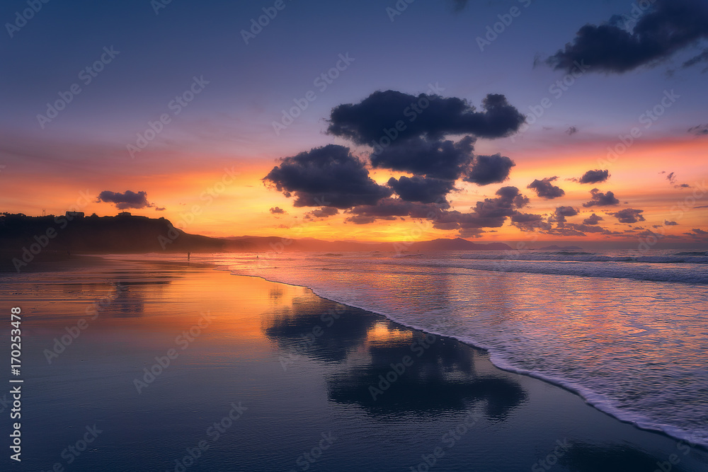 clouds reflections on beach at sunset