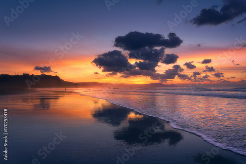 clouds reflections on beach at sunset