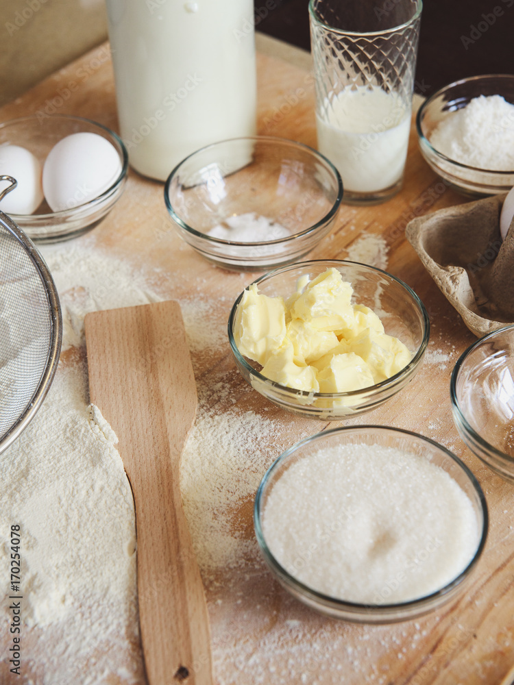 Baking ingredients on kitchen table. White products prepare for cooking on wooden cutting board. Lifestile food concept. Baking ingredients on kitchen table. White products prepare for cooking on wooden cutting board. Lifestile food concept.